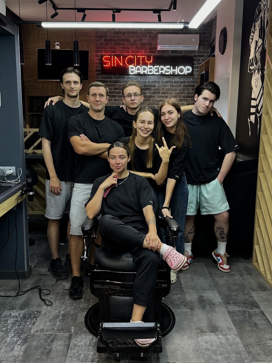 Команда Sin City Barbershop під неоновою вивіскою